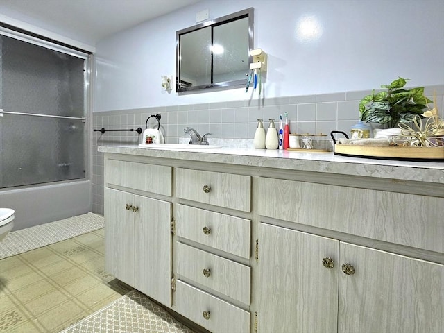 3 Main St, Spencer, MA 01562 - bathroom featuring toilet, vanity, tile walls, bath / shower combo with glass door, and a wainscoted wall
