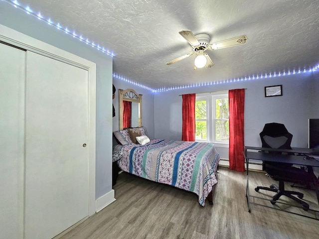 3 Main St, Spencer, MA 01562 - bedroom with wood finished floors, a textured ceiling, baseboards, a baseboard heating unit, and a closet