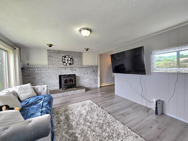 3 Main St, Spencer, MA 01562 - living area with light wood-style flooring, a wood stove, and a textured ceiling