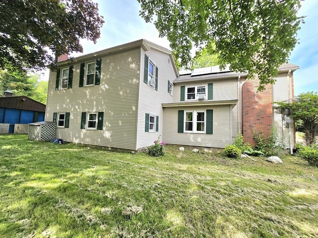 3 Main St, Spencer, MA 01562 - rear view of house featuring solar panels, a yard, a chimney, and an outdoor structure