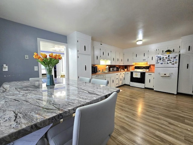 3 Main St, Spencer, MA 01562 - kitchen featuring white appliances, white cabinets, dark wood finished floors, under cabinet range hood, and a sink