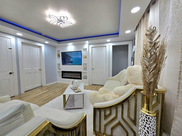 3 Main St, Spencer, MA 01562 - living area with wood finished floors, recessed lighting, a tray ceiling, a glass covered fireplace, and built in shelves