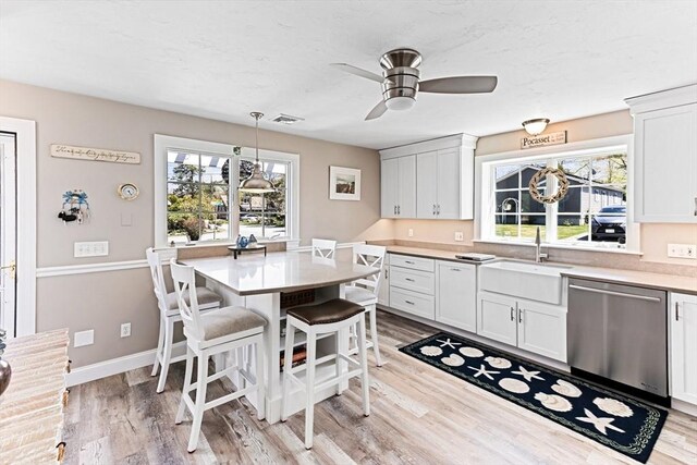 24 Park St, Bourne, MA 02559 - kitchen with a ceiling fan, visible vents, stainless steel dishwasher, a sink, and light wood-style floors