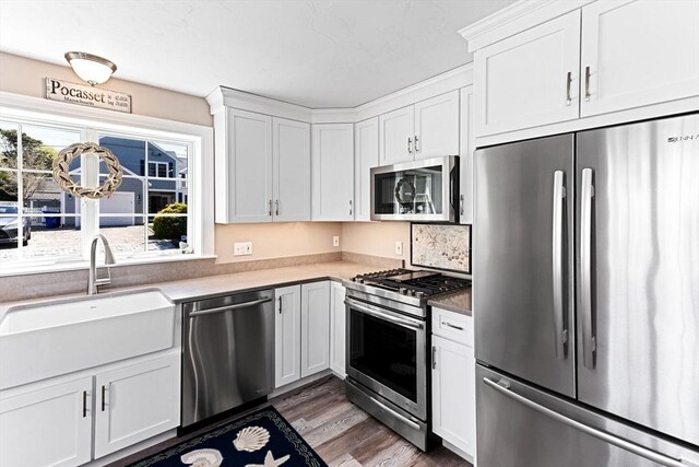 24 Park St, Bourne, MA 02559 - kitchen featuring white cabinets, stainless steel appliances, a sink, and wood finished floors
