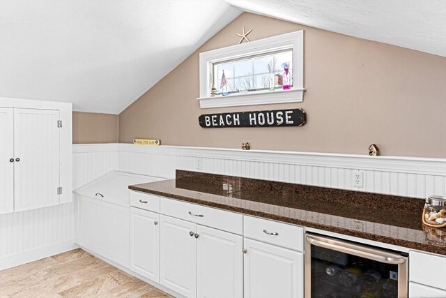 24 Park St, Bourne, MA 02559 - kitchen featuring wine cooler, dark stone countertops, white cabinetry, and lofted ceiling