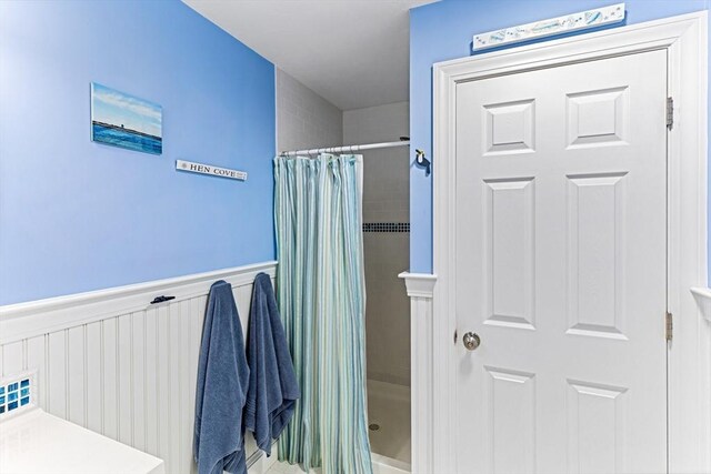 24 Park St, Bourne, MA 02559 - bathroom featuring a wainscoted wall and tiled shower