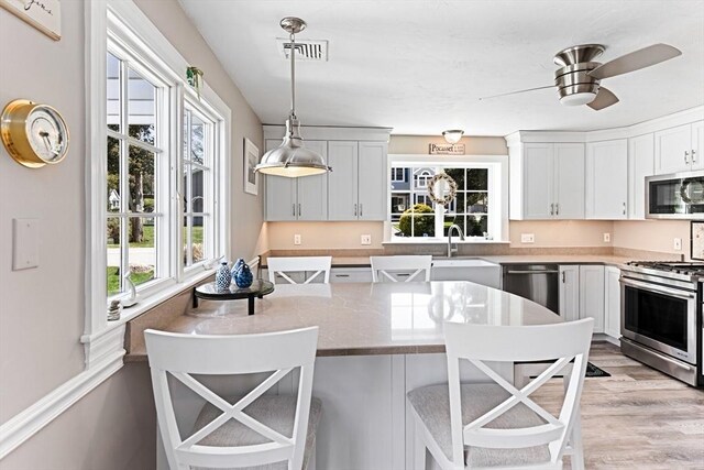 24 Park St, Bourne, MA 02559 - kitchen with a breakfast bar area, stainless steel appliances, visible vents, and a sink