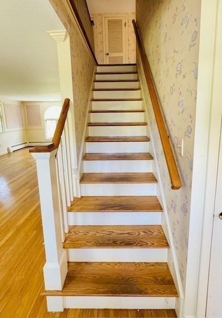 staircase featuring wallpapered walls and wood finished floors