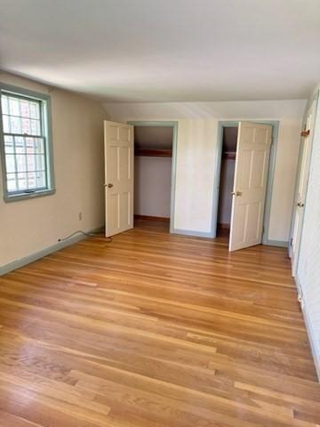 unfurnished bedroom with baseboards and light wood-style flooring