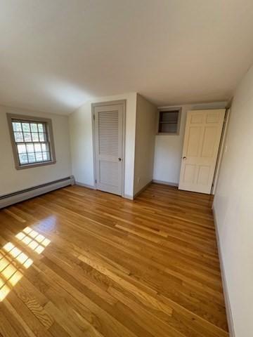 interior space featuring baseboards, a baseboard radiator, and light wood-type flooring