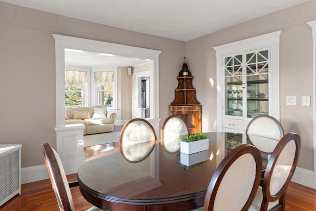 dining area featuring wood-type flooring and radiator heating unit