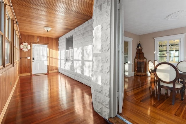 interior space featuring dark wood-type flooring, wooden walls, and wooden ceiling