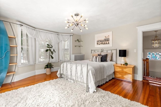 bedroom with hardwood / wood-style floors and an inviting chandelier