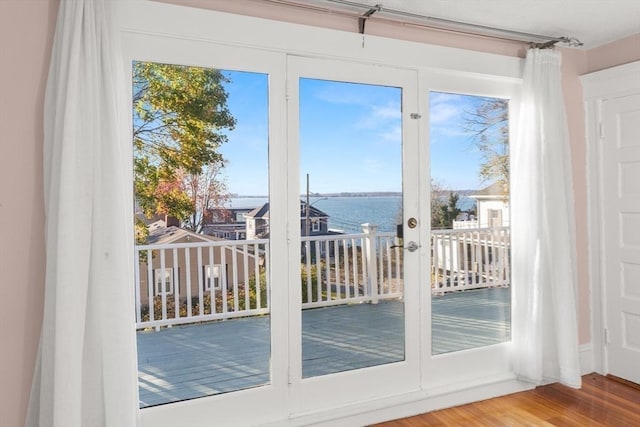 doorway with a water view and hardwood / wood-style floors