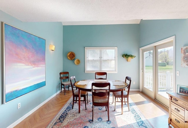 dining space featuring baseboards and a textured ceiling