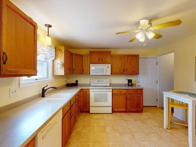 kitchen featuring brown cabinets, a sink, white appliances, light countertops, and a ceiling fan