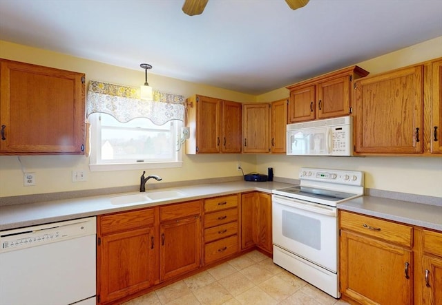 kitchen featuring white appliances, light countertops, brown cabinets, a sink, and hanging light fixtures