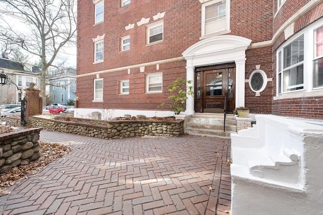 doorway to property with brick siding