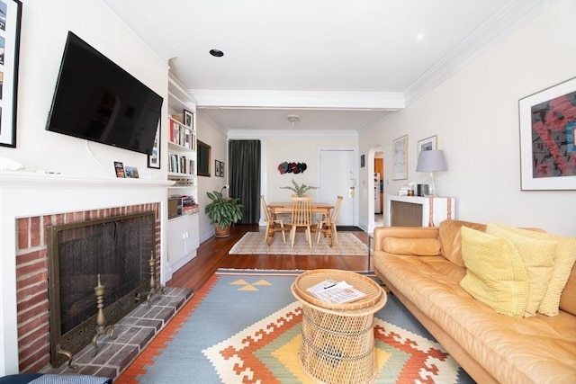 living area featuring a fireplace, crown molding, and wood finished floors