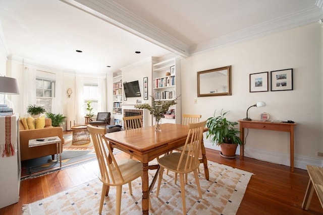 dining space featuring hardwood / wood-style floors, baseboards, and ornamental molding