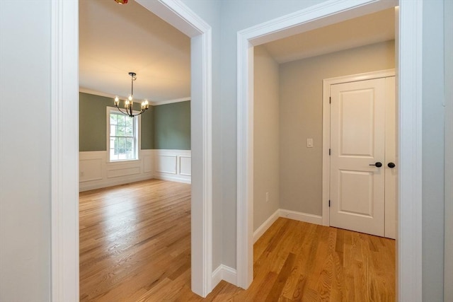 34 Torre St, Reading, MA 01867 - hall featuring light wood-style flooring, a chandelier, wainscoting, and crown molding