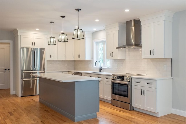 34 Torre St, Reading, MA 01867 - kitchen with wall chimney exhaust hood, stainless steel appliances, light countertops, white cabinets, and recessed lighting
