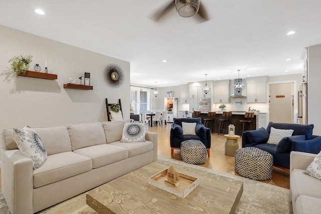 living room featuring ceiling fan and light wood-type flooring