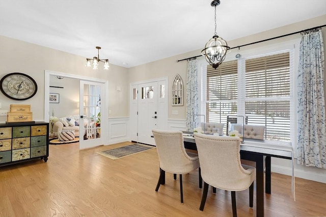 dining room featuring light wood-type flooring and a notable chandelier