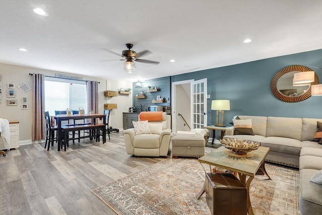 living room featuring light hardwood / wood-style floors and ceiling fan