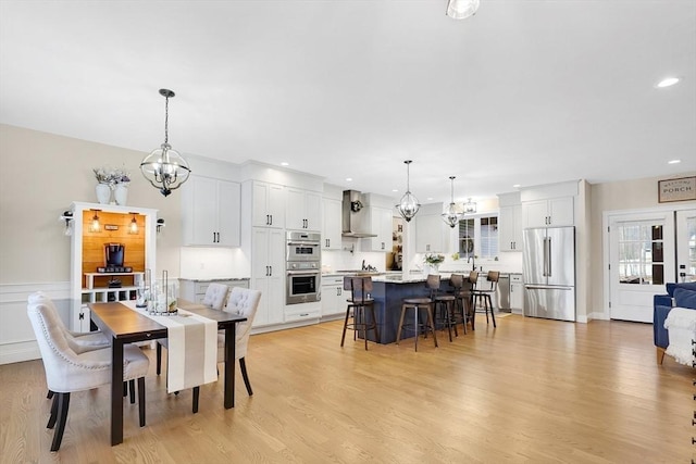 dining room featuring a notable chandelier, light hardwood / wood-style floors, and sink