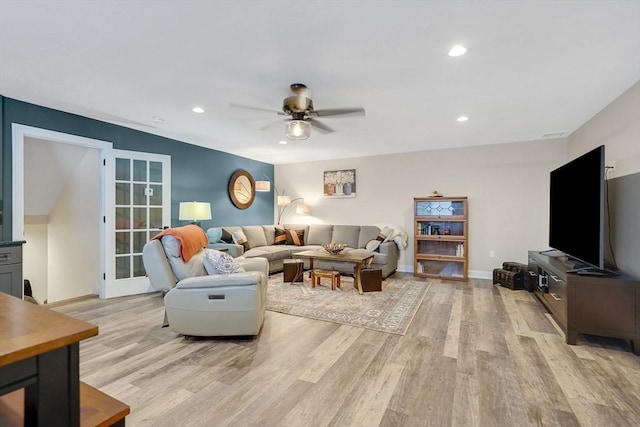 living room with ceiling fan and light wood-type flooring