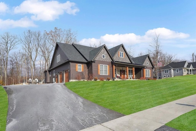 view of front of property featuring a garage, a porch, and a front lawn