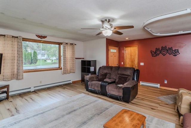 living room featuring a baseboard heating unit, wood finished floors, a baseboard radiator, a ceiling fan, and baseboards