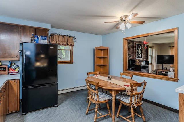 carpeted dining area with a baseboard heating unit and a ceiling fan