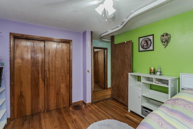 bedroom with wood finished floors, a ceiling fan, and baseboards