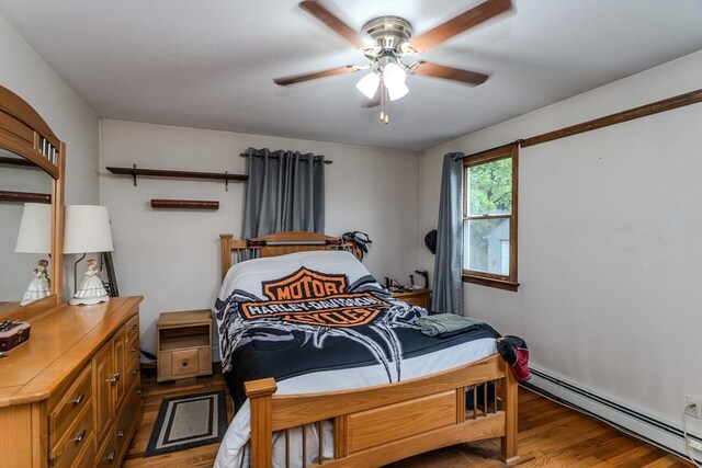 bedroom with baseboard heating, light wood-style floors, and ceiling fan