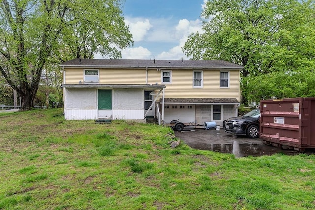 rear view of house with a garage and a lawn