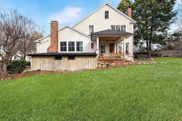 rear view of property featuring a lawn