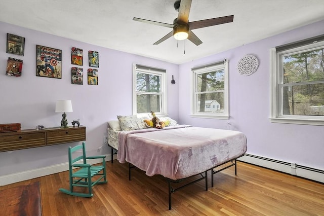 25 Cardigan Rd, Tewksbury, MA 01876 - bedroom with wood finished floors, multiple windows, a baseboard heating unit, and baseboards
