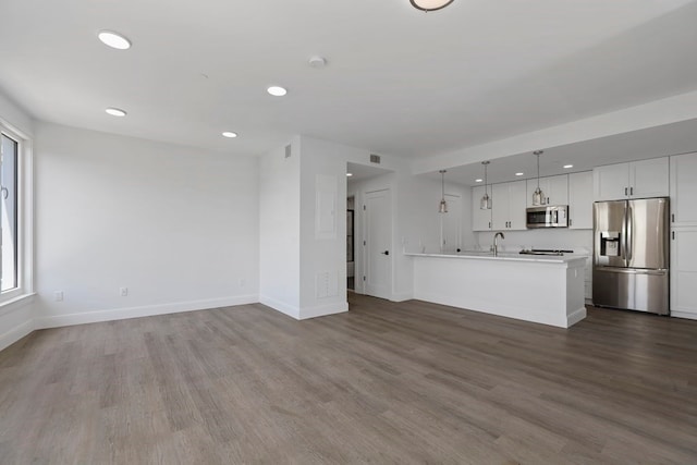 unfurnished living room with wood-type flooring and sink