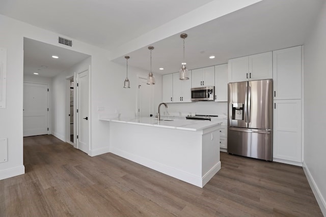 kitchen featuring hanging light fixtures, stainless steel appliances, dark hardwood / wood-style floors, and white cabinetry