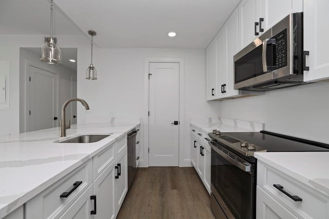 kitchen with white cabinets, pendant lighting, sink, dark wood-type flooring, and appliances with stainless steel finishes