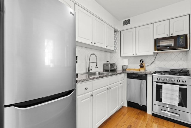 17 Bowdoin Unit 2B, Boston, MA 02114 - kitchen with stainless steel appliances, a sink, white cabinets, and decorative backsplash