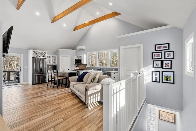 living room featuring high vaulted ceiling, beam ceiling, and light hardwood / wood-style floors