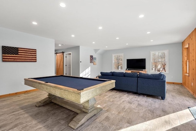 game room featuring light hardwood / wood-style floors, billiards, a barn door, and wooden walls