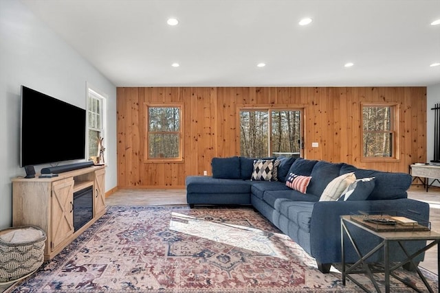 living room featuring light wood-type flooring and wood walls