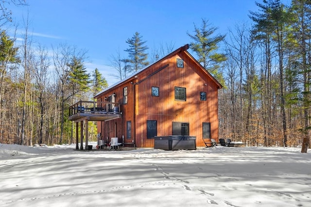 exterior space featuring a wooden deck and a hot tub