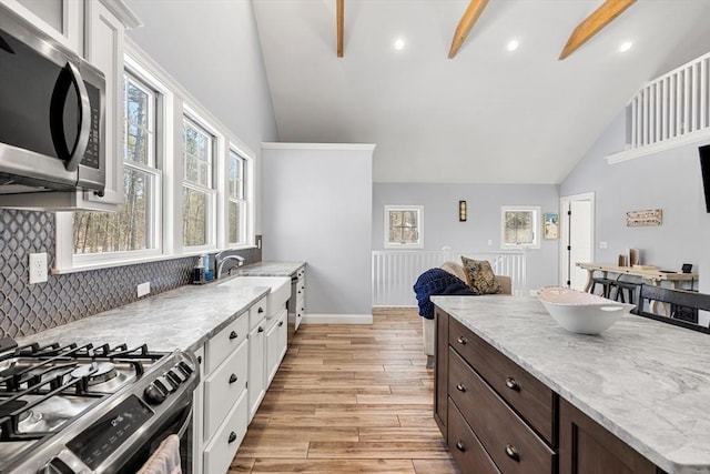 kitchen with sink, stainless steel appliances, white cabinetry, and light hardwood / wood-style floors