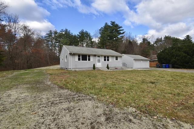 view of front of house featuring a garage, an outdoor structure, and a front yard