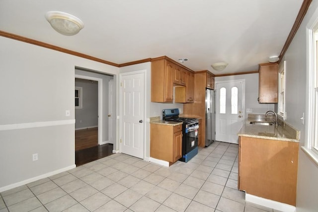 kitchen with sink, light tile patterned floors, ornamental molding, appliances with stainless steel finishes, and light stone countertops